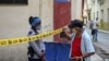 Una oficial de policía exige identificación a un ciudadano en una calle de La Habana cerrada por coronavirus. (YAMIL LAGE / AFP)
