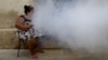Una mujer fuma mientras soldados fumigan su vivienda para eliminar el agente transmisor del dengue y zika en La Habana. (Archivo-REUTERS/Ueslei Marcelino)