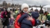Una mujer que huyó de Ucrania carga a su hijo a su llegada al cruce fronterizo de Medyka, el lunes 28 de febrero de 2022, en Polonia. (AP Foto/Visar Kryeziu)