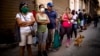 Cubanos hacen fila para comprar alimentos.