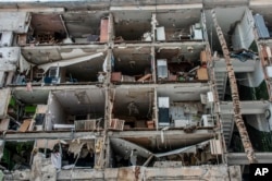 Un edificio de apartamentos se ve destruido por ataques en Járkiv, Ucrania, el domingo 13 de marzo de 2022. (AP Foto/Andrew Marienko)